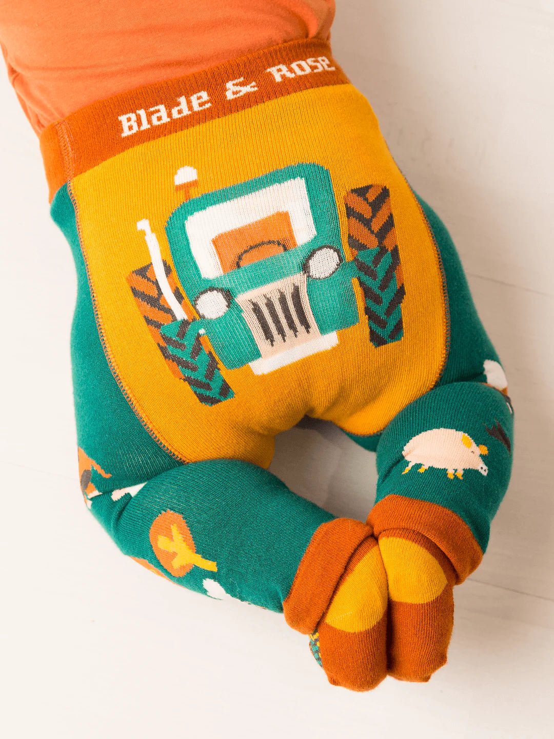Colorful children's neck pillow with tractor design and 'Blade & Rose' branding.