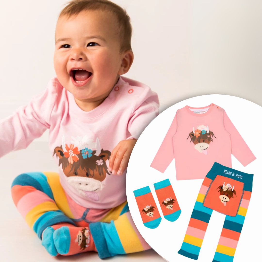Baby wearing a pink outfit with a cow design, surrounded by matching clothing items on a white background.