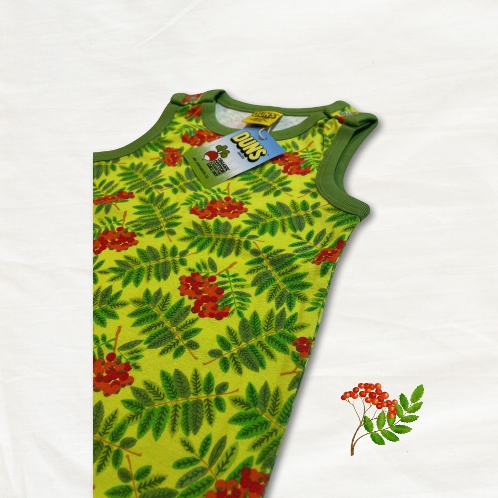 Green sleeveless dungarees with red berry pattern on a white background