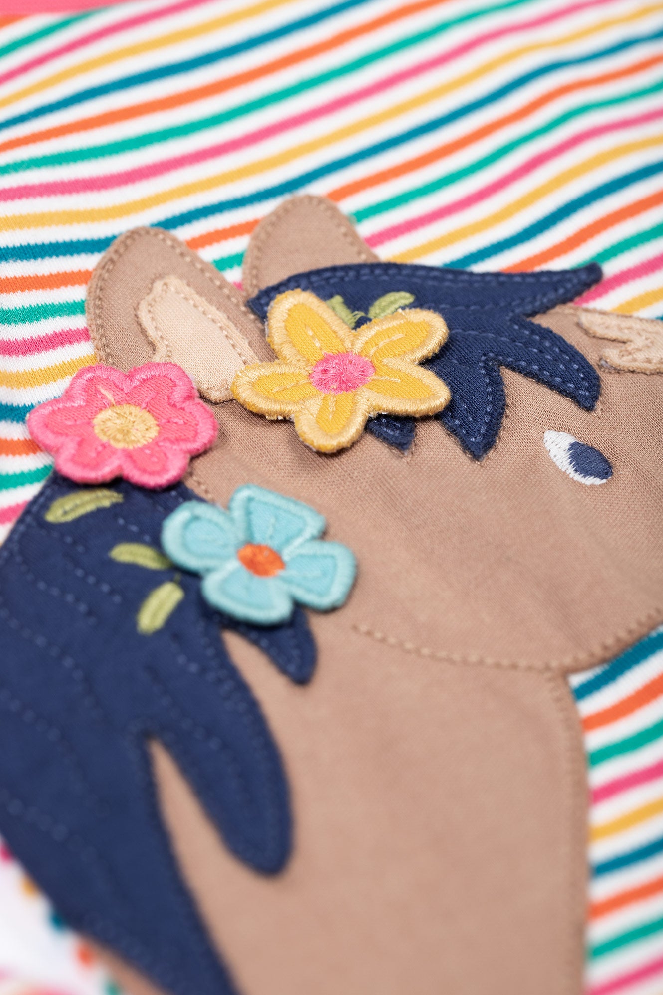 Children's shoe with floral decorations on a striped background