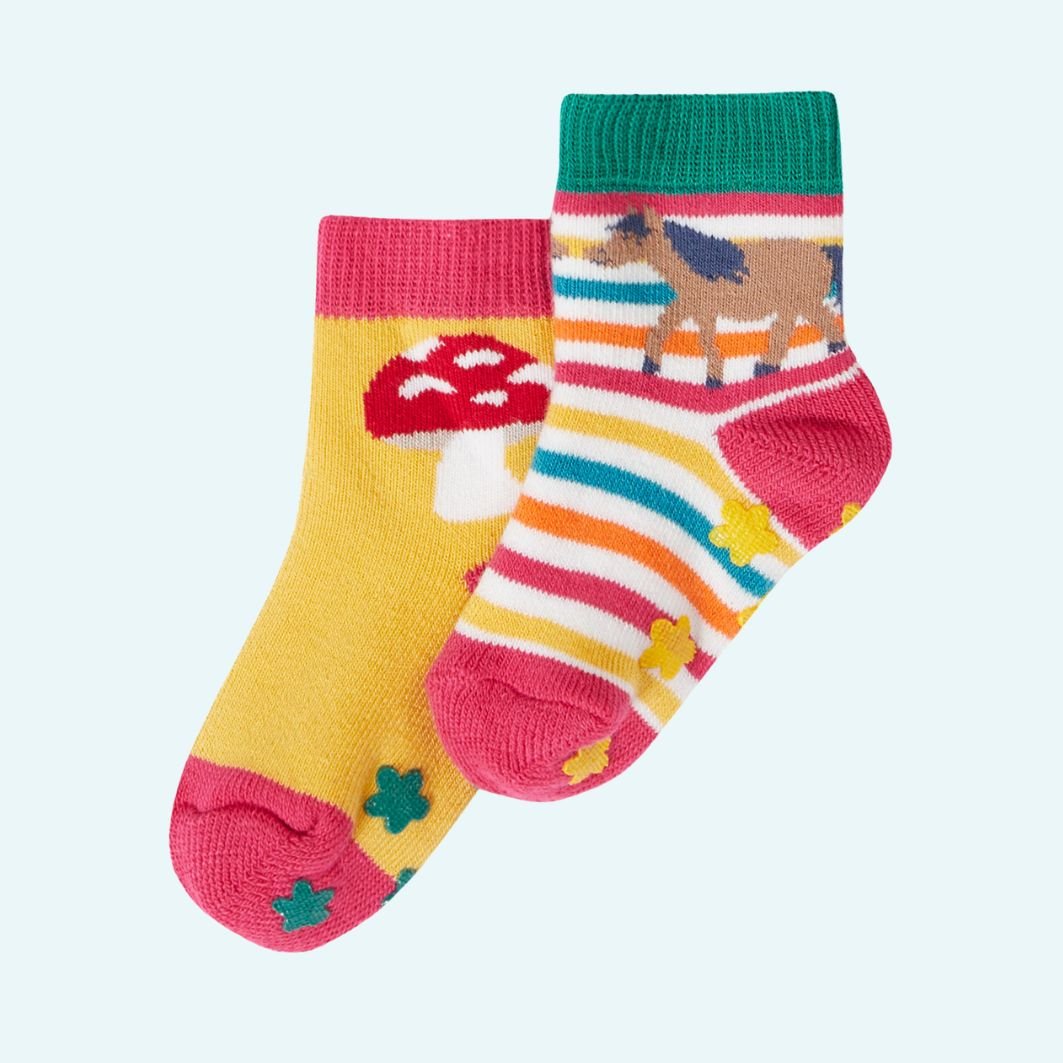 Two pairs of colorful children's socks with animal and mushroom designs on a light blue background.