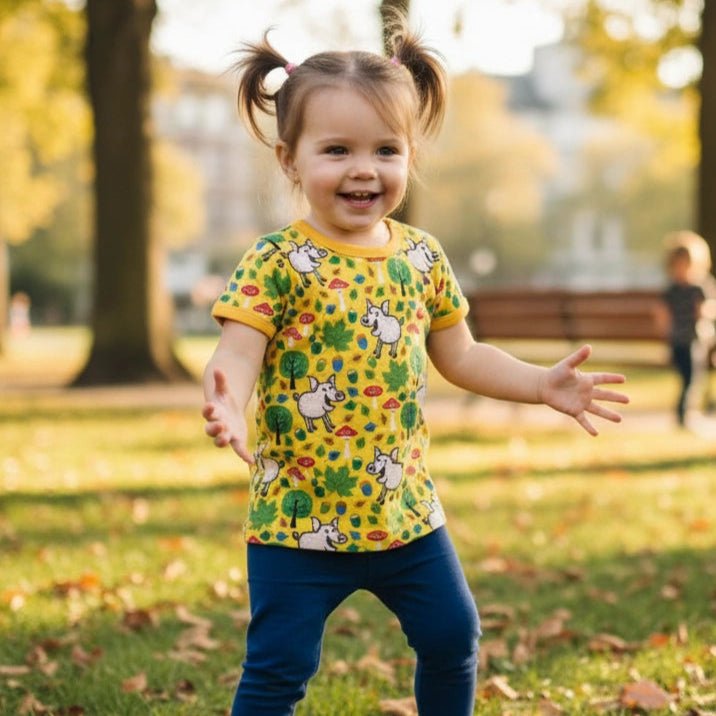 Child wearing a colorful shirt with animal prints in a park setting