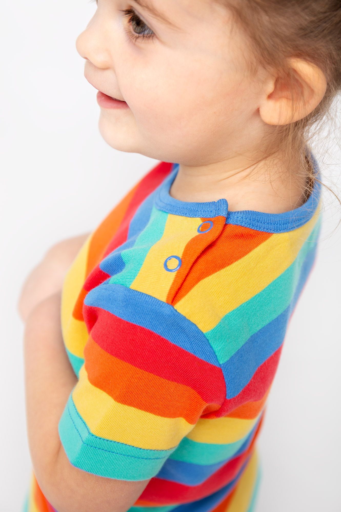 Child wearing a colorful striped shirt on a plain background