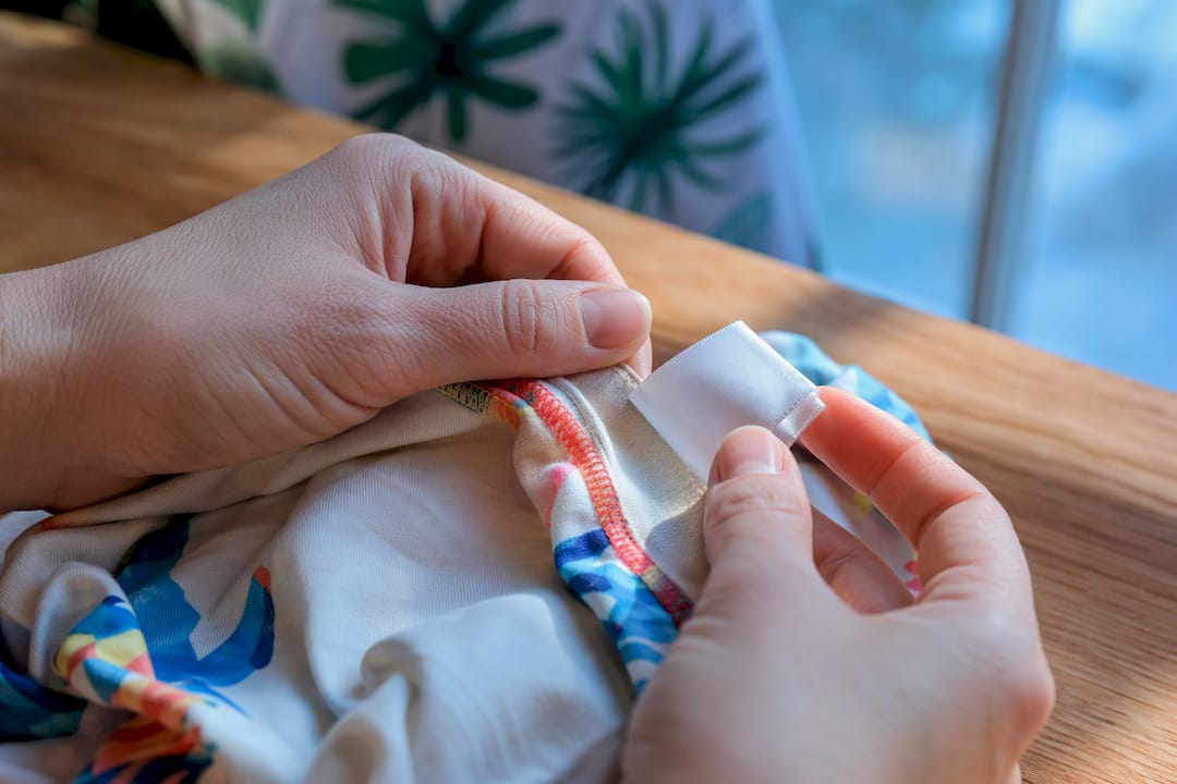 Parent inspecting anonymous kidswear garment label