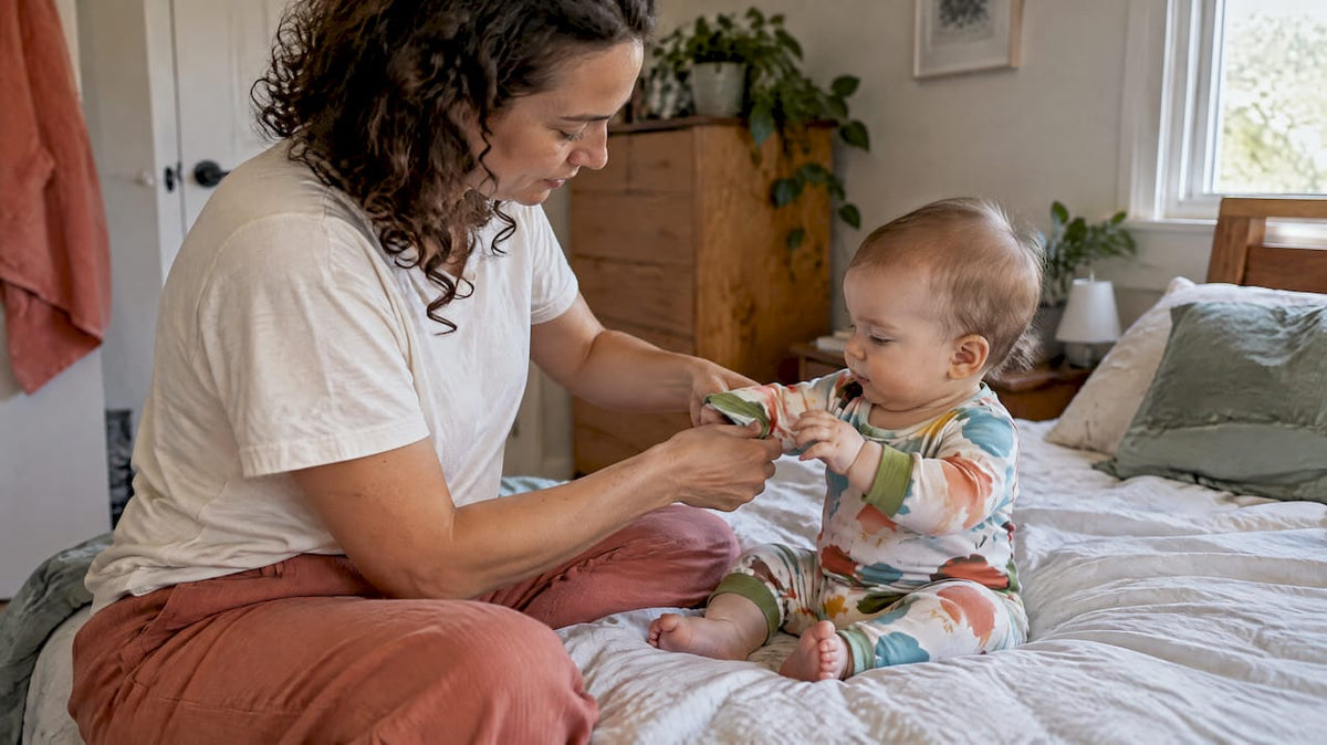 Parent dressing baby in colourful neutral outfit