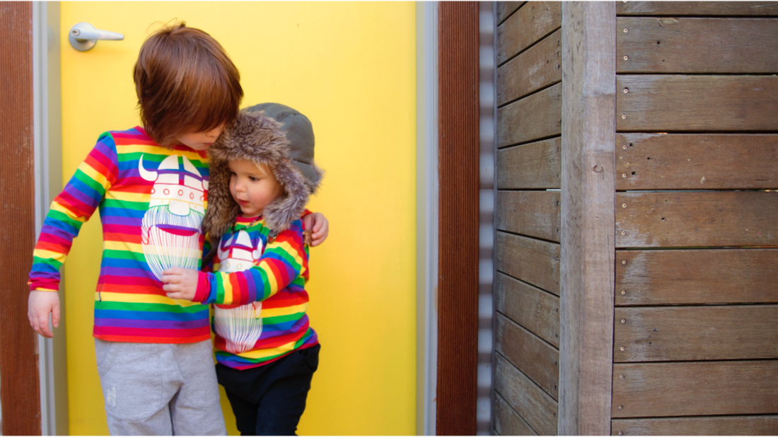 Two children wearing kids rainbow clothes