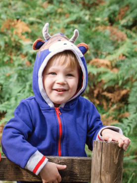 Child wearing a blue hoodie with a hood featuring animal ears and a nose, standing outdoors.