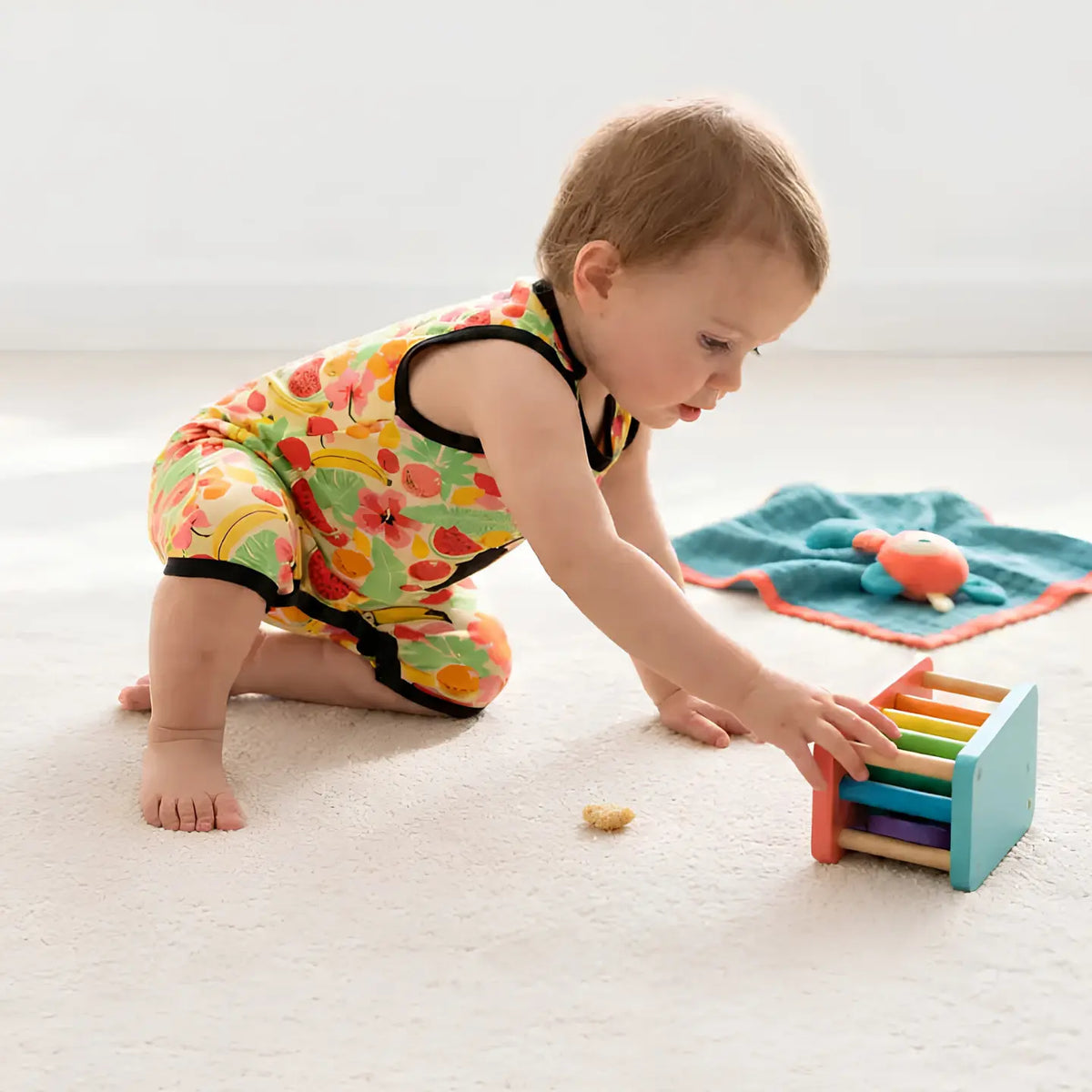 Baby wearing a bright infant romper with rainbow colors