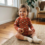 A baby girkl sitting on her floor wearing a duns sweden bodysuit