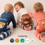 Three babies crawling in matching Blade & Rose animal-print onesies: blue leopard, brown striped with a cow graphic, and coral leopard.