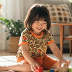 Child playing with colorful blocks on a light-colored rug in a bright room.