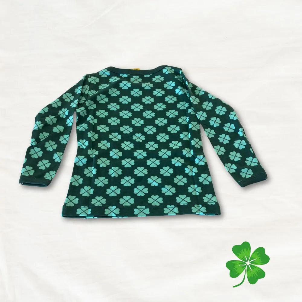 Green long-sleeve shirt with clover pattern on a white background
