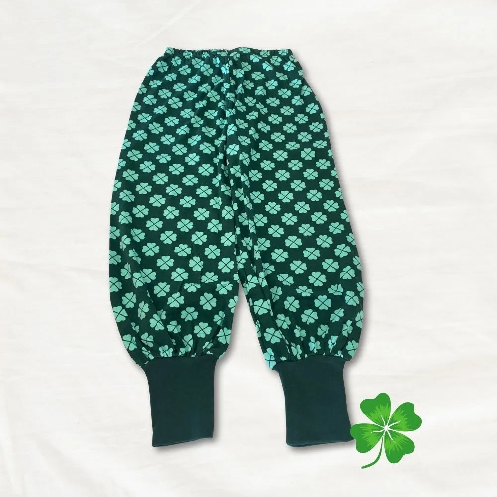 Green baby pants with clover pattern on a white background