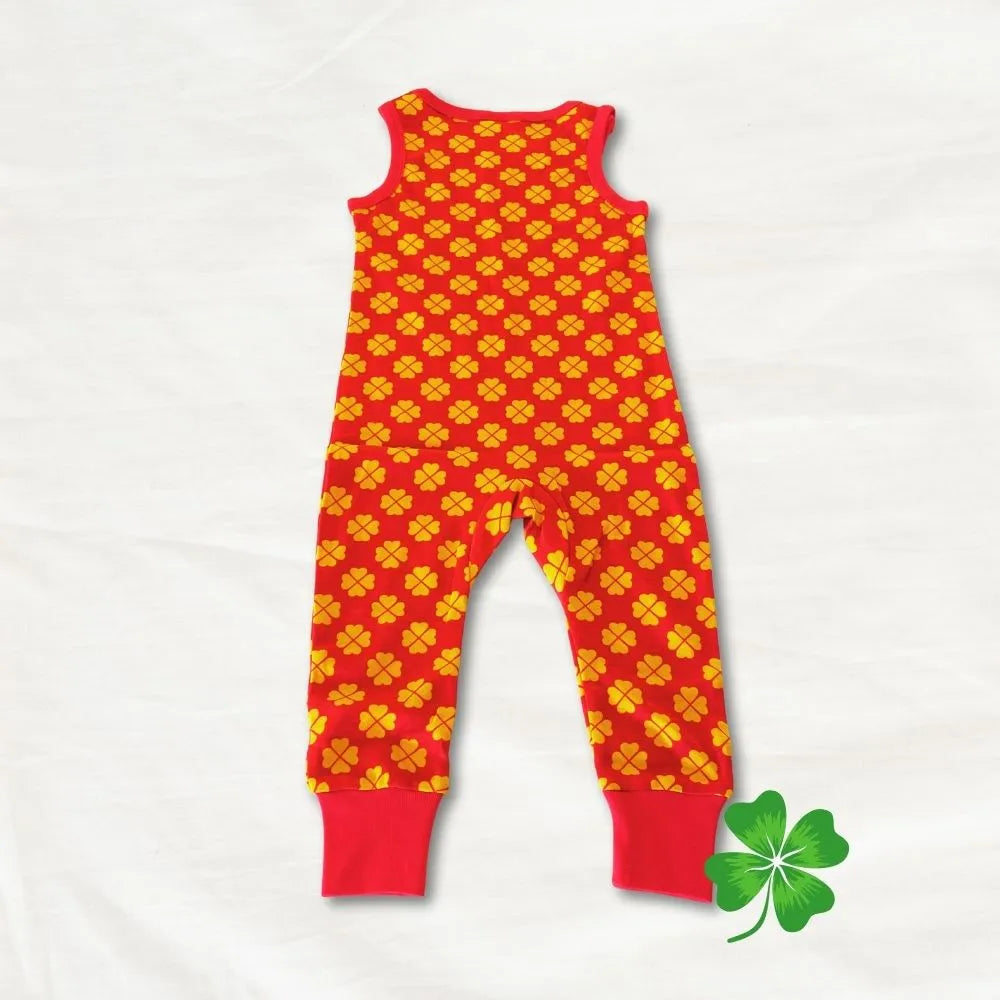 Red and yellow patterned romper on a white background with a green shamrock leaf.