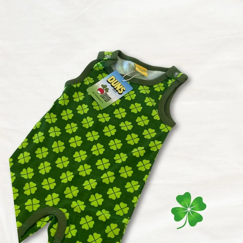 Green baby romper with four-leaf clover pattern on a white background