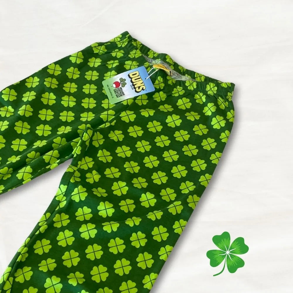 Green fabric with four-leaf clover pattern and a visible brand tag on a white background.