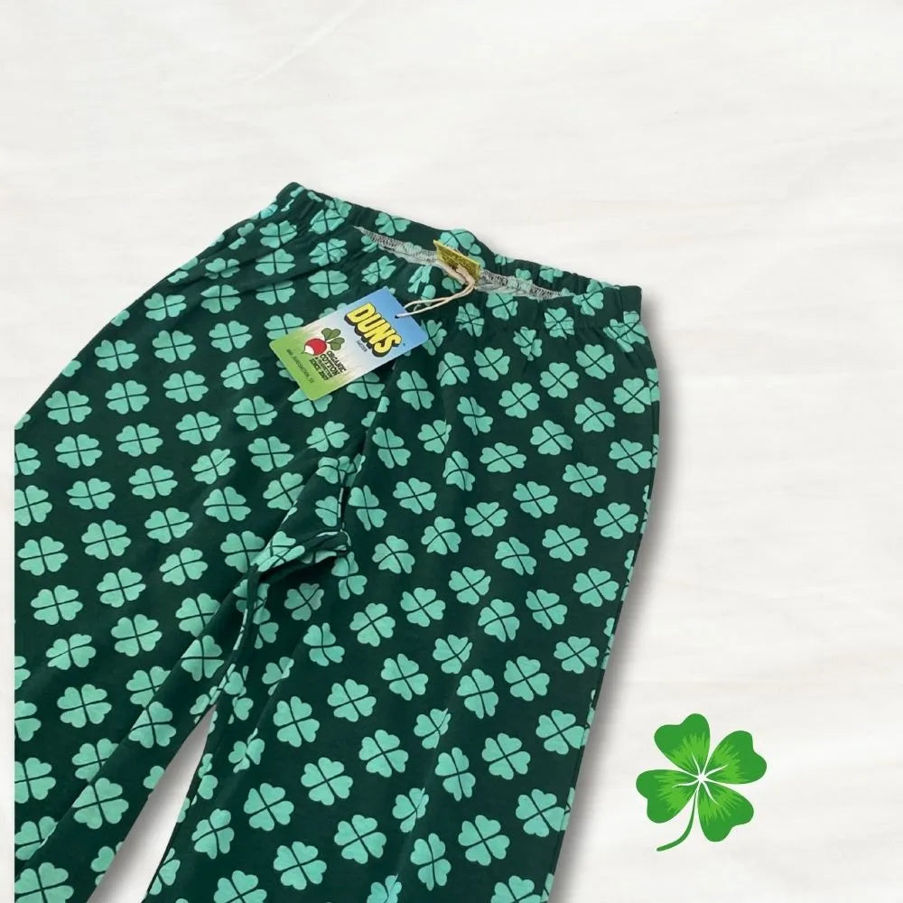 Green pants with four-leaf clover pattern on a white background