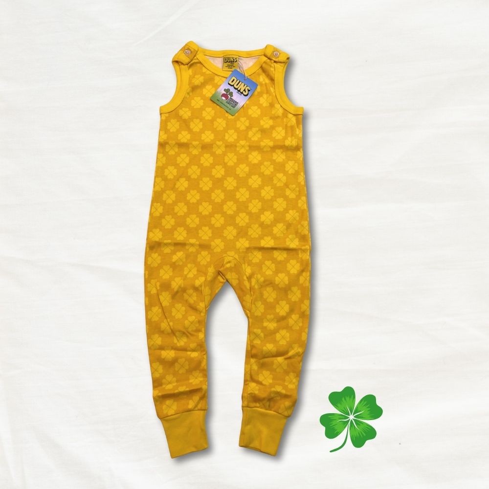 Yellow children's clover romper with a green tag on a white background