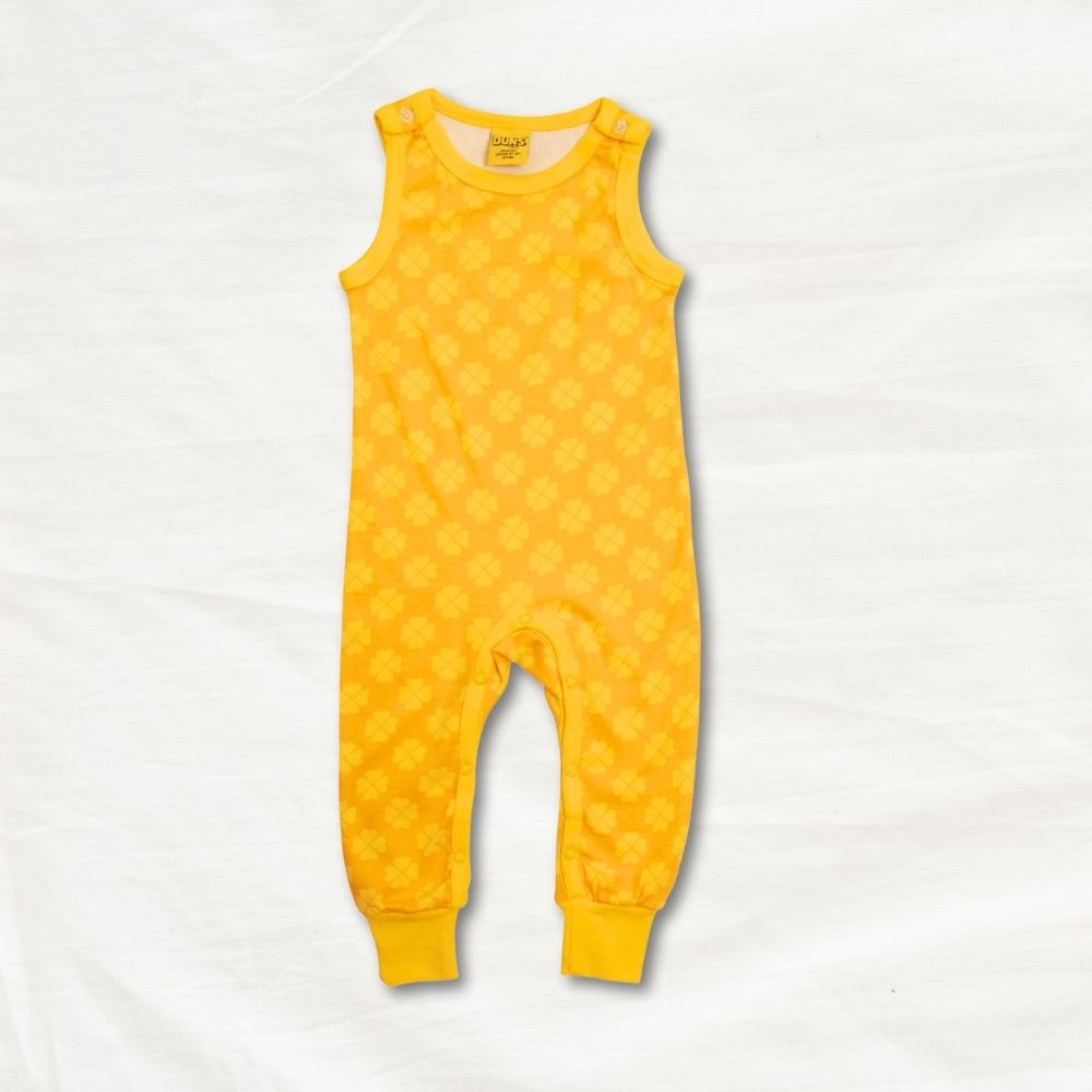Yellow baby romper with a clover pattern on a white background