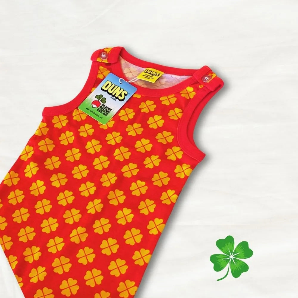 Red sleeveless dress with yellow clover pattern on a white background