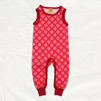 Red baby romper with clover print pattern on a white background