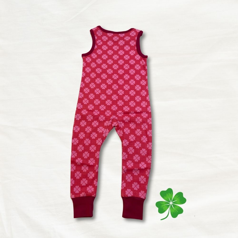 Pink patterned clover onesie on a white background with a green leaf logo.