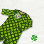 Green baby onesie with clover pattern on a white background