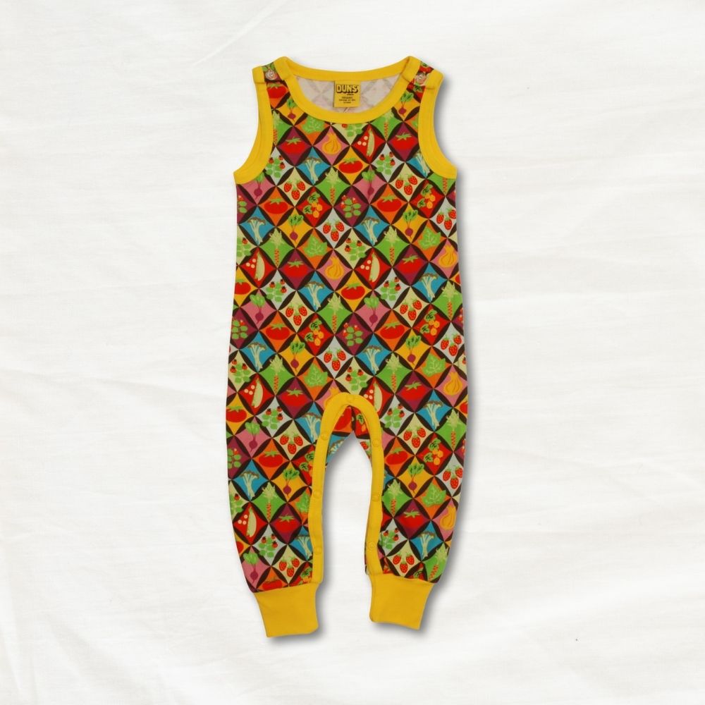 Colorful patterned baby romper with yellow trim on a white background