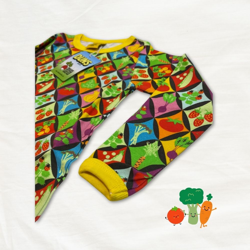 Colorful children's top with vegetable pattern on a white background
