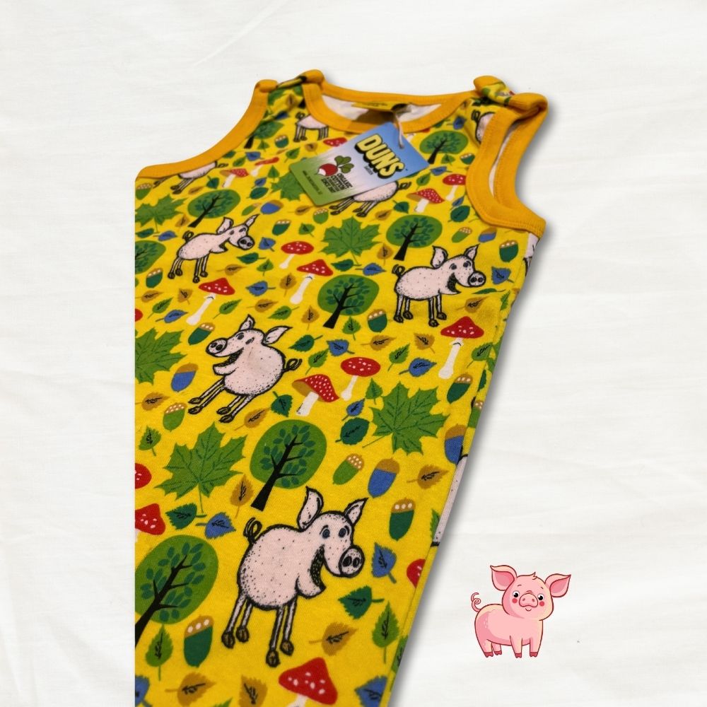 Yellow sleeveless dungarees with pig and forest pattern on a white background