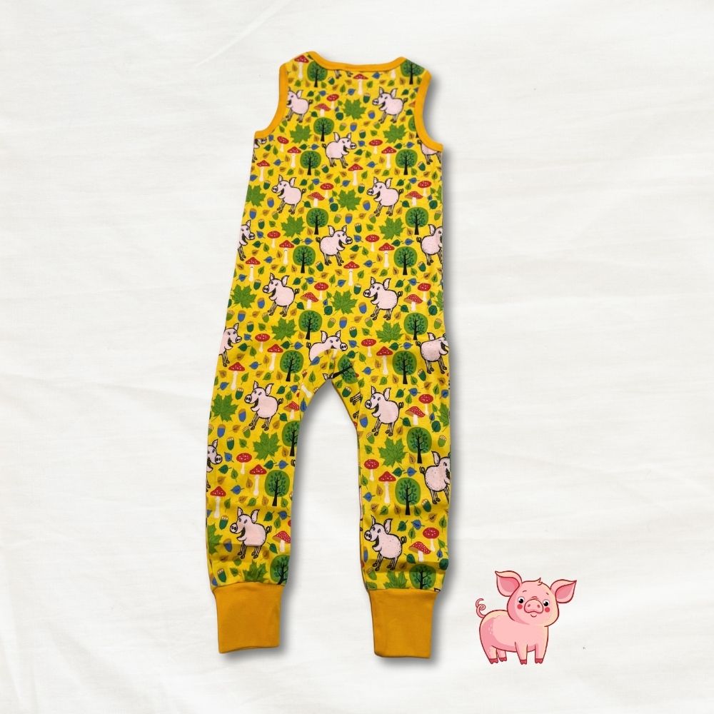 Yellow children's romper with pig pattern on a white background