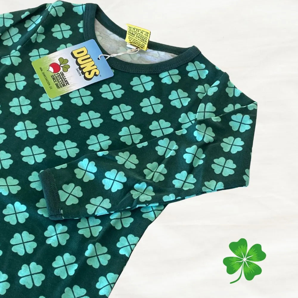 Green shirt with blue four-leaf clover pattern on a white background