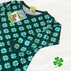 Green shirt with blue four-leaf clover pattern on a white background