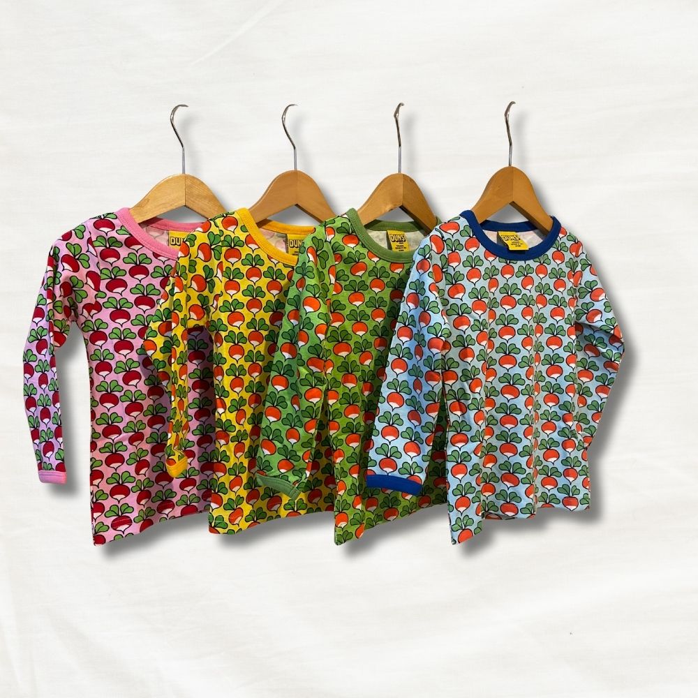 Four children's long-sleeve shirts with radish patterns on hangers against a white background