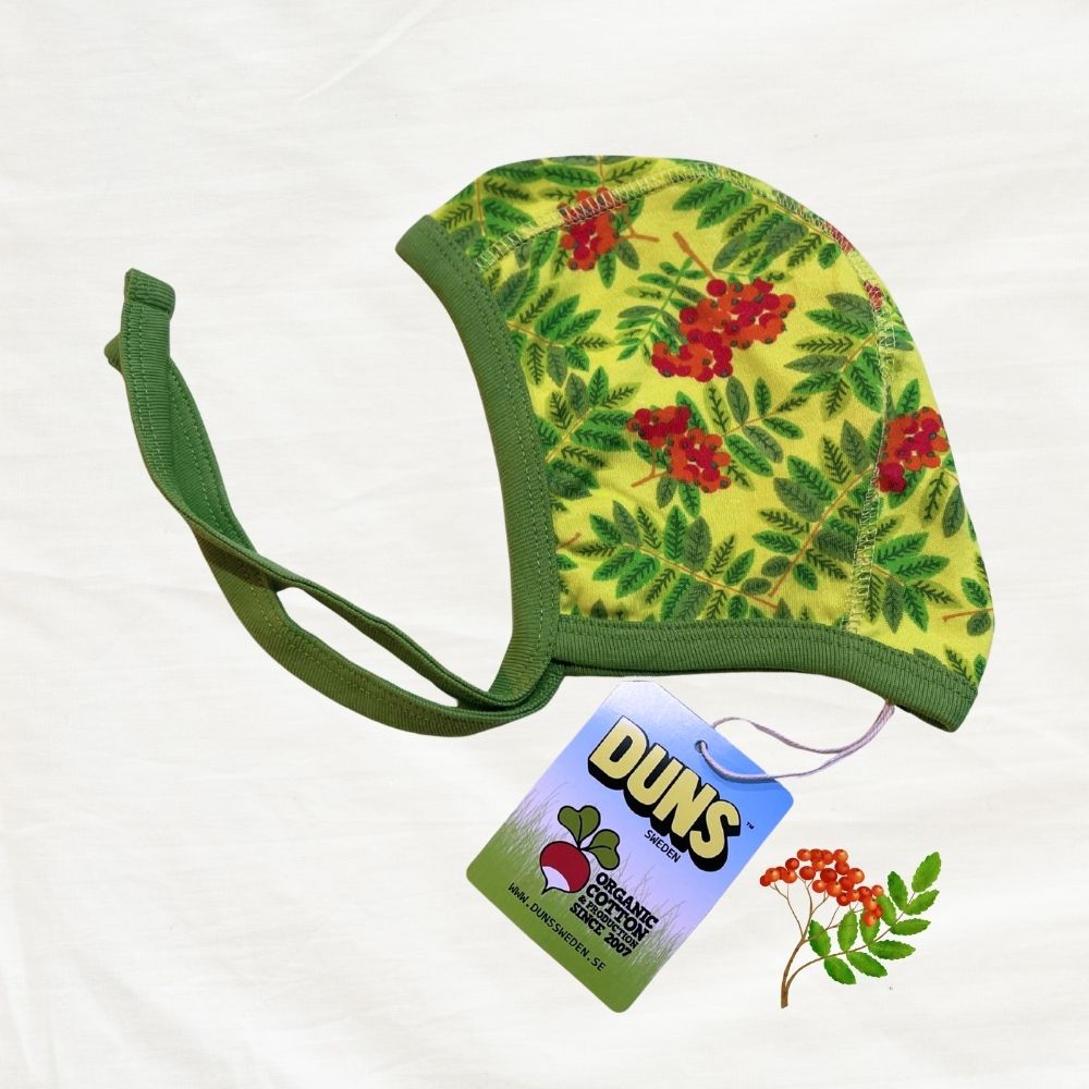 Floral-patterned baby hat with green brim and tag labeled 'Duns' on a white background