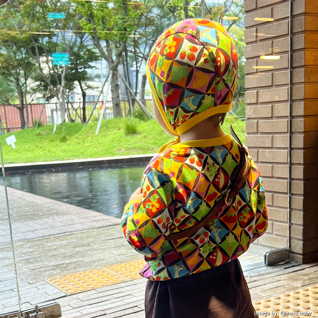 Small boy wearing veggie print top