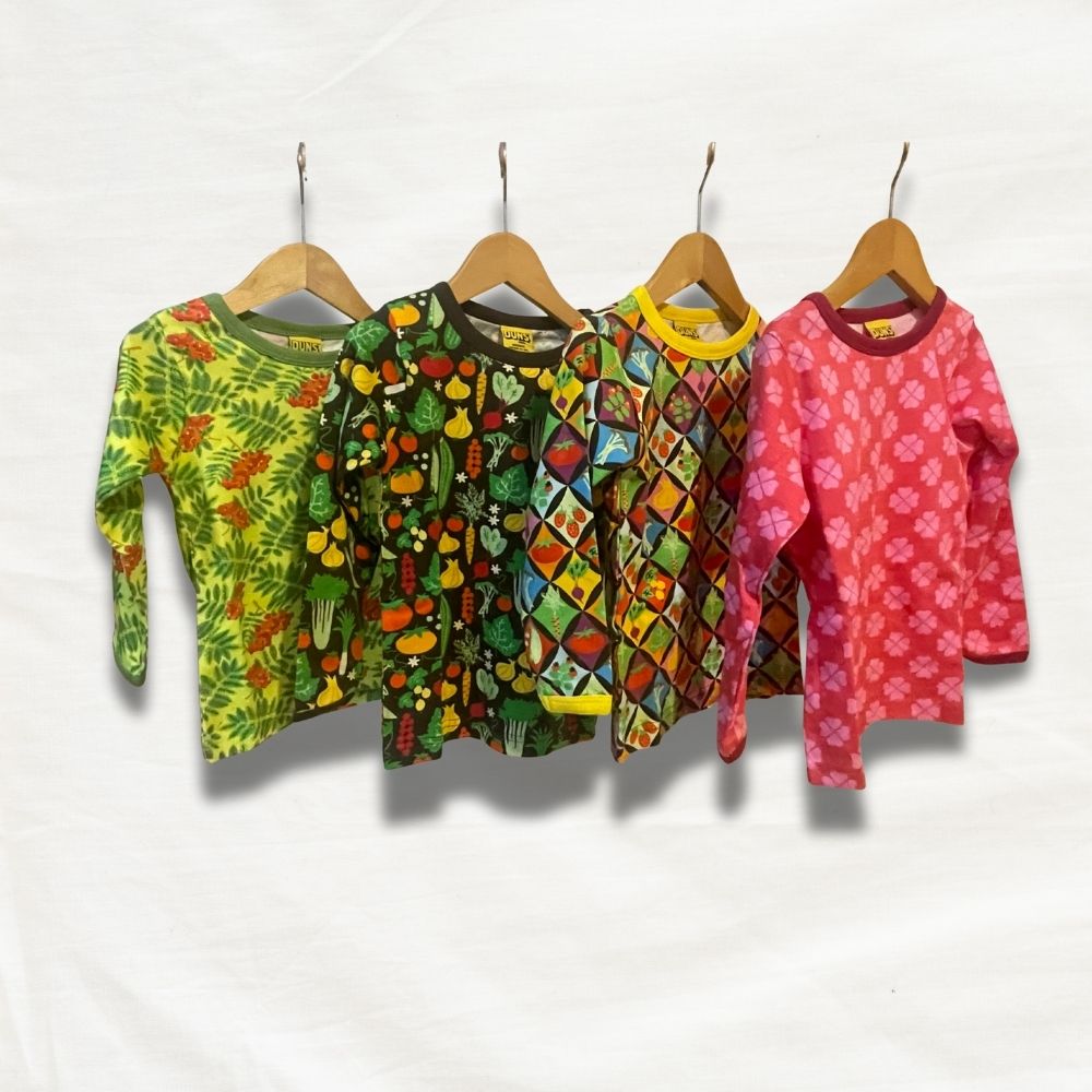 Five colorful children's long-sleeve shirts on hangers against a white background