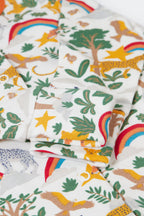 Fabric with jungle-themed pattern featuring animals, trees, and rainbows.