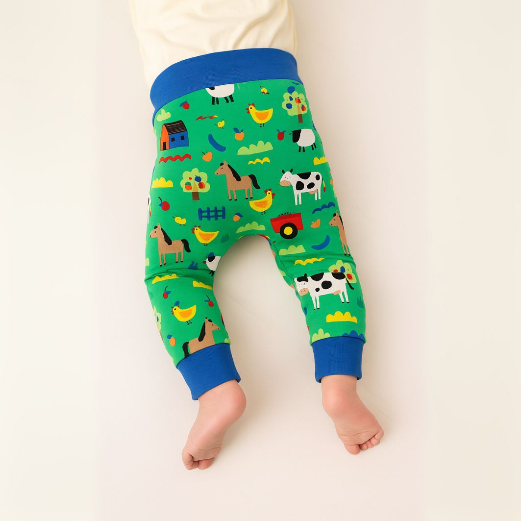 Children's green pants with farm animal pattern on a white background