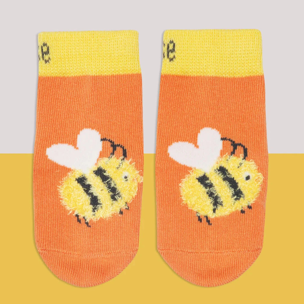 Pair of socks with bee design on a yellow and gray background