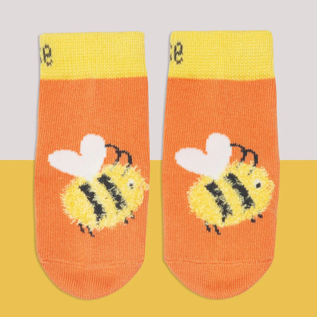 Pair of socks with bee design on a yellow and gray background