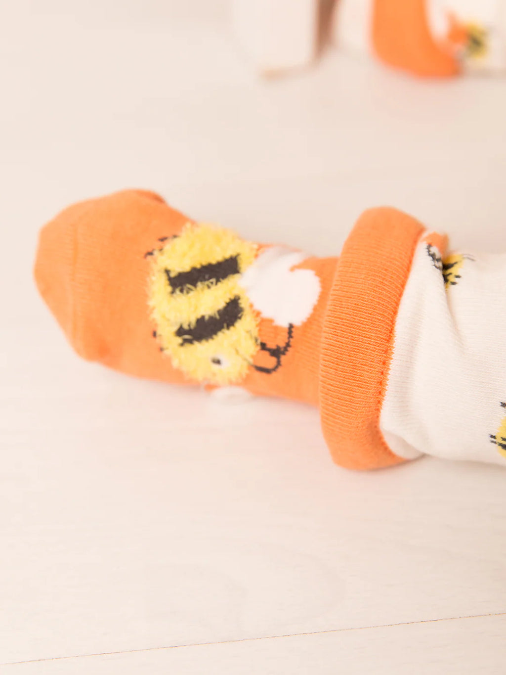 Orange socks with lion design on a light background