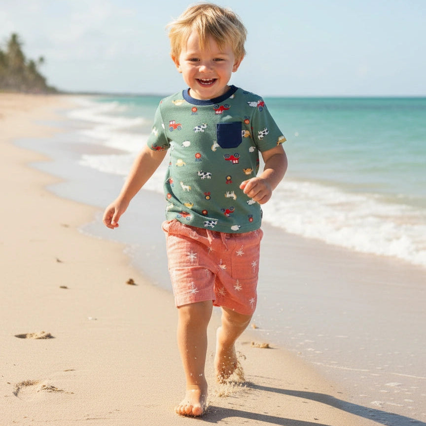 Child walking on a sandy beach with ocean and sky in the background