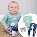 Baby wearing a light blue onesie with a duck design, sitting on a carpeted floor.