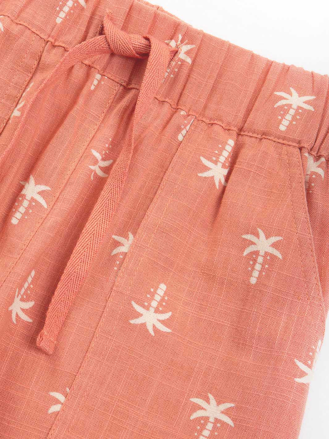 Red shorts with white palm tree pattern on a white background