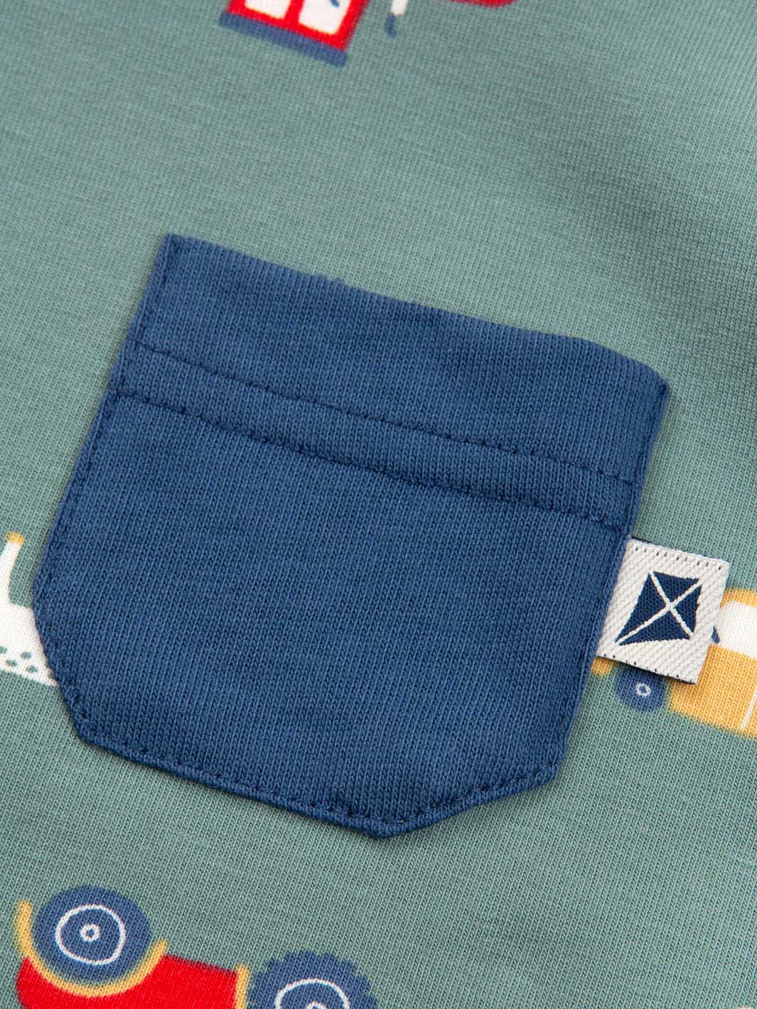 Close-up of a blue pocket on a fabric with colorful patterns, featuring a brand label.
