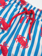 Blue and white striped swim shorts with red crab pattern and red drawstring.