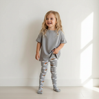 Child wearing a gray outfit with rainbow patterns on a white background