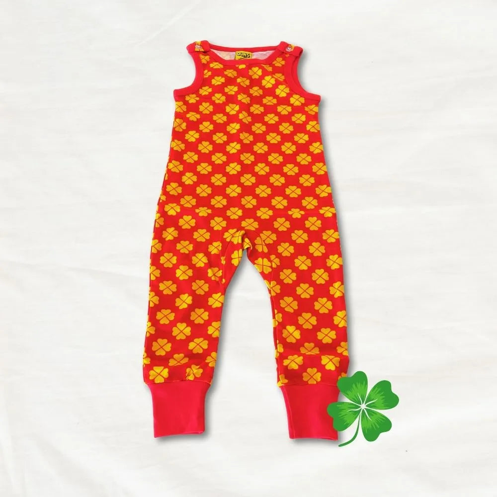 Red and yellow patterned romper with a green four-leaf clover on a white background