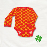 Red baby onesie with yellow patterns on a white background